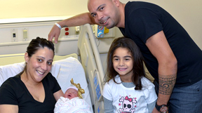 La madre Rosemary Espinal sostiene a la bebé Olivia en compañía del padre Freddy Peña y la hermana Arianna. 