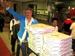 Helena Yordan, Coordinadora del programa escolar extracurricular de CHCF recibiendo la donación de Domino’s Pizza.