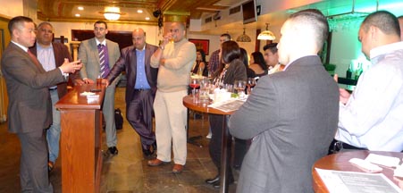 John Liu, al extremo izquierdo, hablando frente a un reducido grupo.