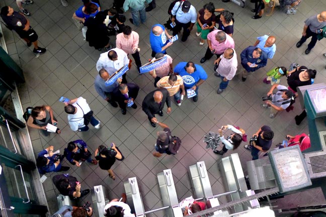 Bill Thompson saludando a transeúntes en la estación de la calle 74 en Jackson Heights, Queens. 