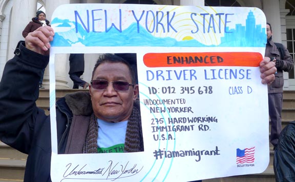 El indocumentado Antonio Rivera posa con un cartel en forma de licencia de conducir.