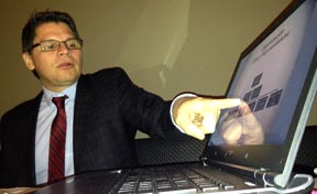 Zoilo Nieto explicando su plataforma en un computador portatil en el restaurante Boulevard de Queens. Foto Javier Castaño
