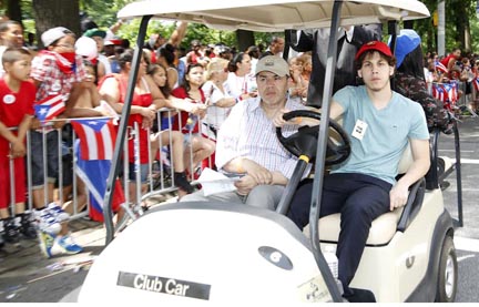 Carlos Velásquez, a la izquierda, durant el Desfile Puertorriqueño en la Quinta Avenida y en compañía de su hijo Charlie, quien conduce el carro. Foto Vicent Villafañe