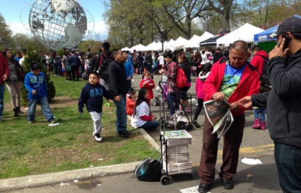 Un representante de QueensLatino repartiendo copias del periódico en el Parque Flushing.