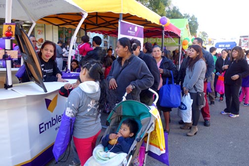 La familia García impulsando la ruleta y recibiendo bolsas de HemblemHealth.