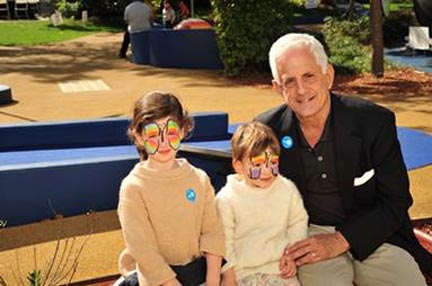 Joseph J. Abularrage, M.D., chairman, Department of Pediatrics, with two of his grandchildren at Healthy Kids and Family Day.