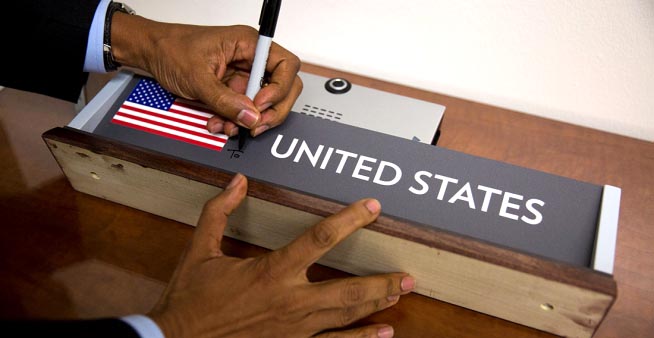 El presidente Obama firmando un letrero de identificación de los Estados Unidos.