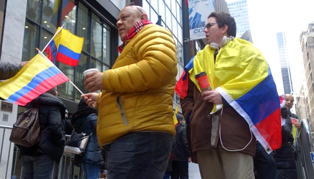 Brand Bedoya, de chaqueta, y Gabriel Chávez envuelto en la bandera colombiana, protestando frente al consulado de Colombia en Nueva York. Fotos Javier Castaño 