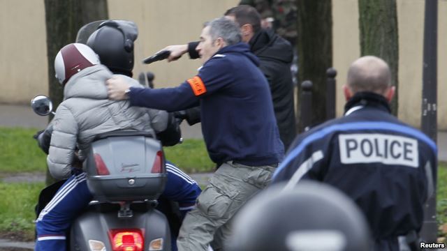 Policías frances arrestan a dos jóvenes en una motocicleta cuando se acercaban a la zona donde un atacante ha tomado rehenes en un supermercado judío en el este de París.