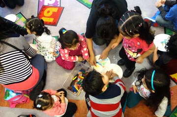 Los niños aprendiendo la importancia de la lectura con la ayuda de sus padres en la Biblioteca de Corona.