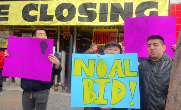 El comerciante Rubén Peña con un letrero de No al BID, y Percy Luján a la derecha.