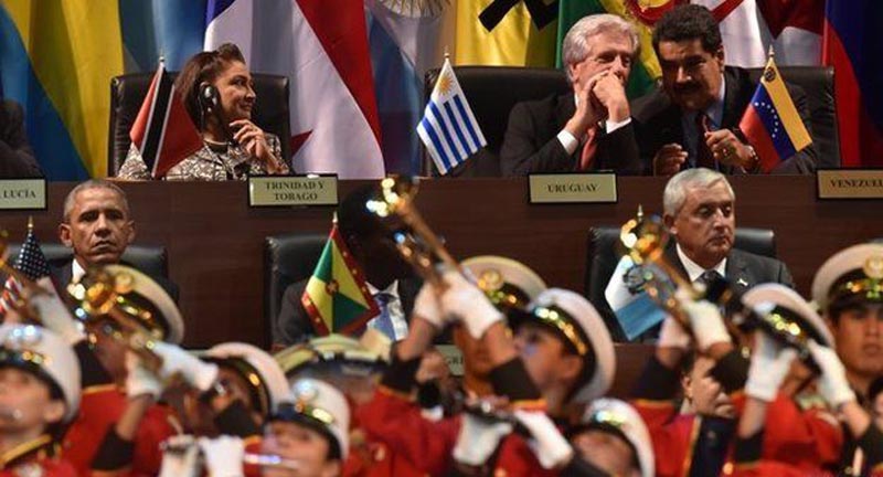 El presidente Obama, a la izquierda, y los presidentes de Uruguay y Venezuela secreteando a la derecha. 