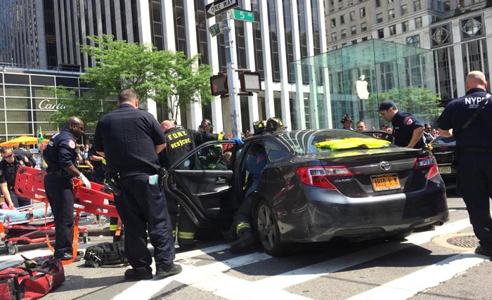 El carro contra el poste y la tienda de Apple al fondo.