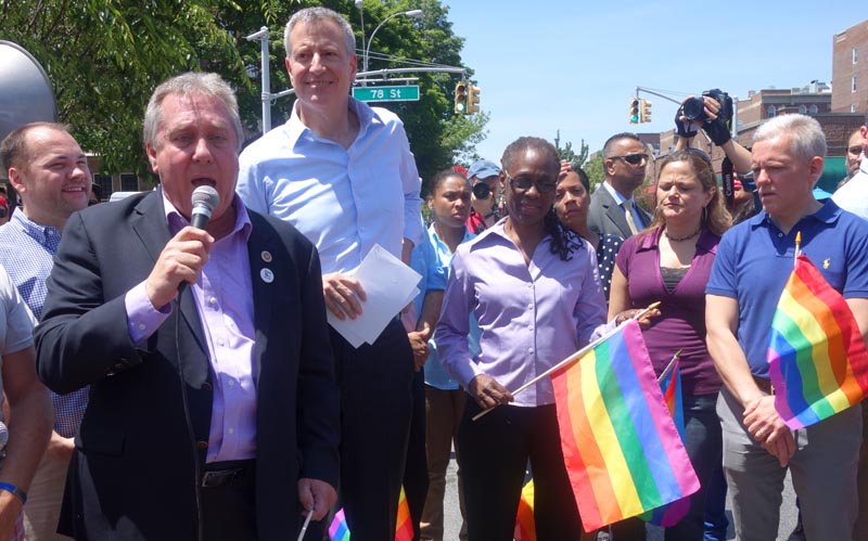 El concejal Daniel Dromm con el micrófono y al lado del alcalde Bill de Blasio y de otros políticos de la ciudad de Nueva York.