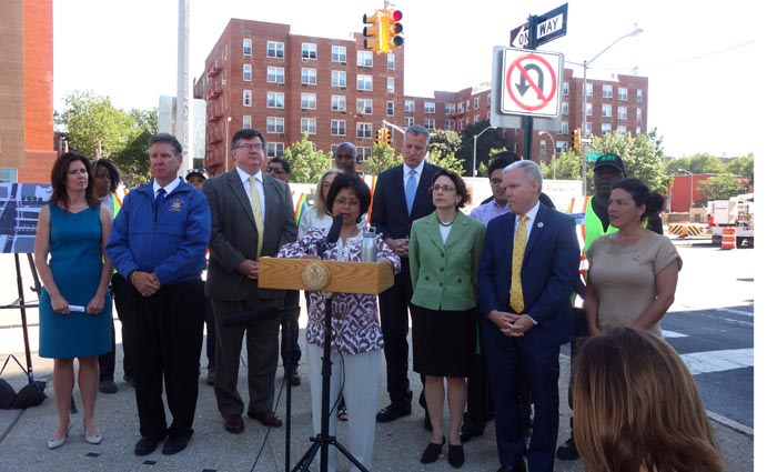 La madre Lici Rahman, quien perdió a su hijo en un accidente en Queens Boulevard, habla a la prensa rodeada de políticos y activistas comunitarios.