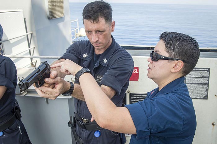 Fire Controlman 2nd Class Melissa Melendez, right, from Queens, N.Y., instructs Electronics Technician 1st Class Jason Cranford on proper grip during M9 9mm pistol weapons familiarization training aboard the dock landing ship USS Fort McHenry (LSD 43). Fort McHenry is a part of the Iwo Jima Amphibious Ready Group (ARG), and, with the embarked 24th Marine Expeditionary Unit (MEU), is deployed in support of maritime security operations and theater security cooperation efforts in the U.S. 5th Fleet area of operations. (U.S. Navy Photo by Mass Communication Specialist 3rd Class Adam Austin/Released)