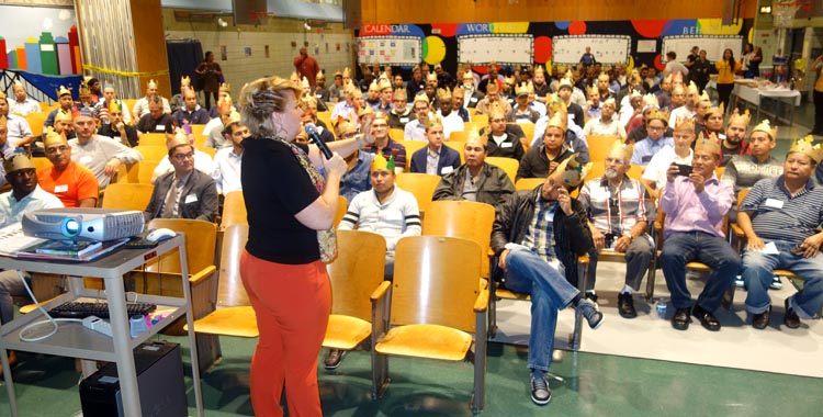 La directora Rebecca Heyward dirigiémdose a los papás en el auditorio de la escuela.