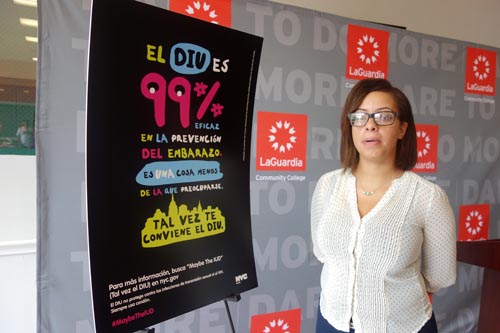 Carla Peralta, estudiante de LaGuardia, al lado del afiche para la campaña del método anticonceptivo 
