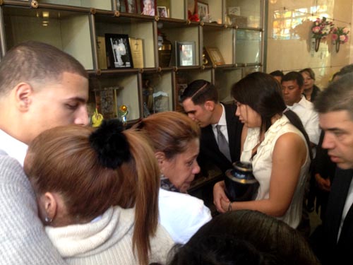 Karliz Velásquez sosteniendo la urna con las cenizas de su hermano Charles Velásquz y rodeada de su familia en el cementerio Sant MIchael's. Foto Javier Castaño