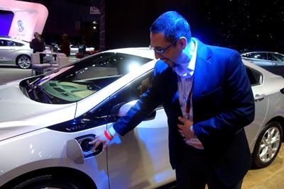 Javier Guzmán de la General Motors señalando la conexión del sistema de carga eléctrica de uno de los autos de la Chevrolet. 