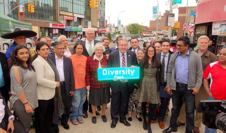 El concejal Daniel Dromm sosteniendo un aviso de Diversity Plaza y rodeado de políticos y activistas.