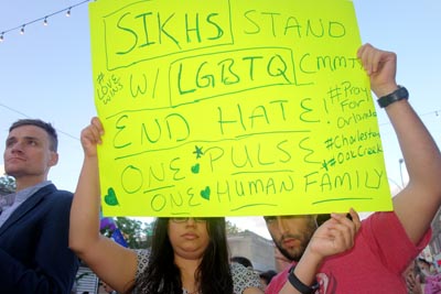 Una pareja sostiene un letrero condenando el odio y defendiendo a los musulmanes y gays.