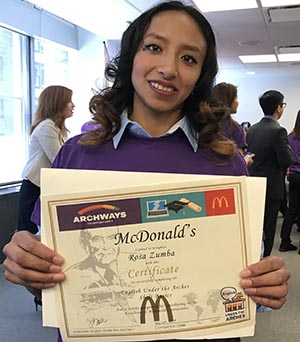 Zumba Rosa, empleada de McDonald's exhibiendo su cartón de graduación de ESL.