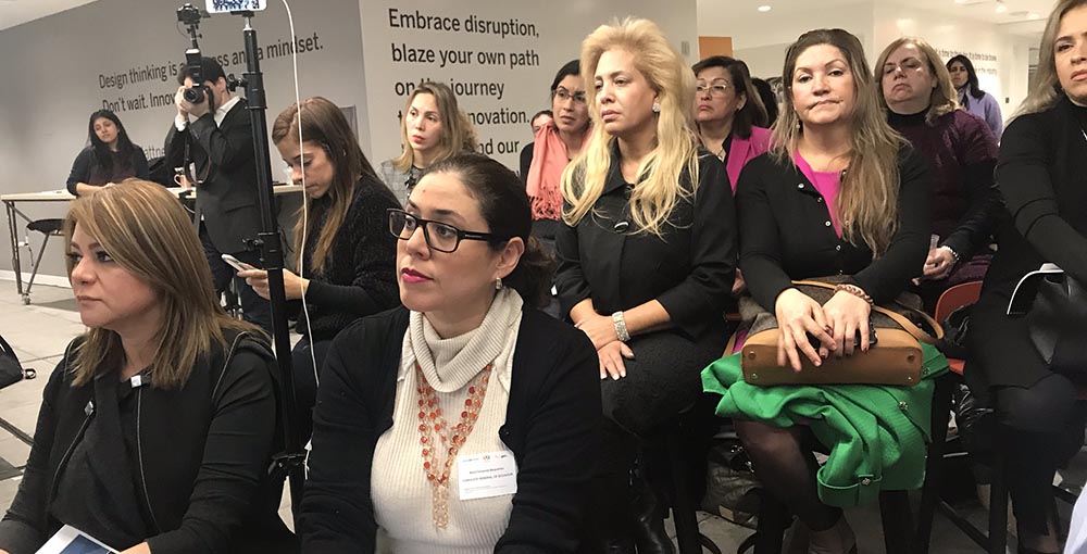 Representantes de la Cámara de Mujeres de Queens escuchando el debate sobre el informe.