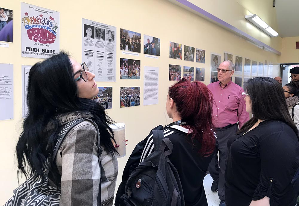 Estudiantes observando la exhibición de fotos del Desfile del Orgullo Gay en Queens.