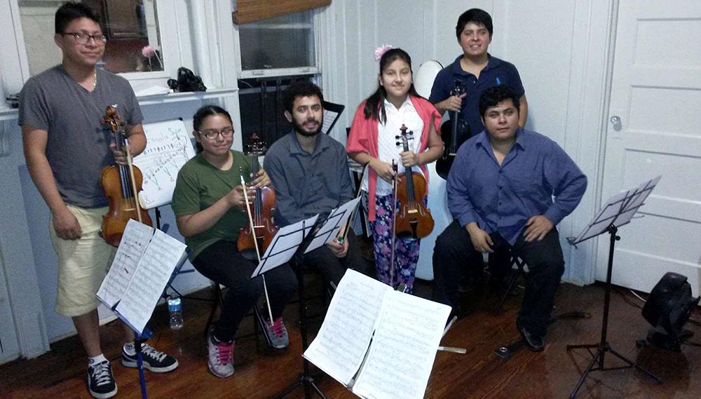 Los músicos de Soloist in America con alumnos.