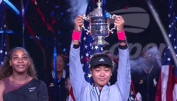 La tenista Naomi Osake levanta el trofeo del US Open ante la mirada de Serena Williams.