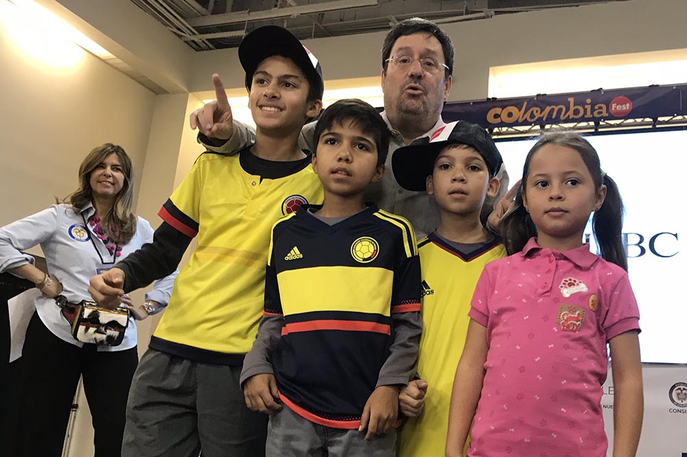 Francisco Santos, embajador de Colombia en Washington, abrazando niños colombianos en la tarima y al fondo María Isabel Nieto, cónsul general de Colombia en Nueva York, quien se retira de su cargo a finales de este mes. Foto Javier Castaño