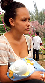 Madre hondureña cargando a su recién nacido rumbo a la frontera.